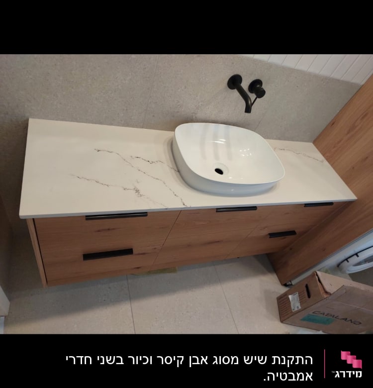 שיש לבן עם עורקים כהים ליד כיור לבן